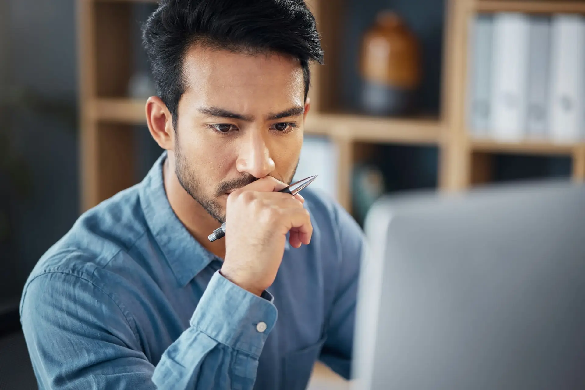 Serious, business man and thinking on computer in office, internet research and website. Focused ma